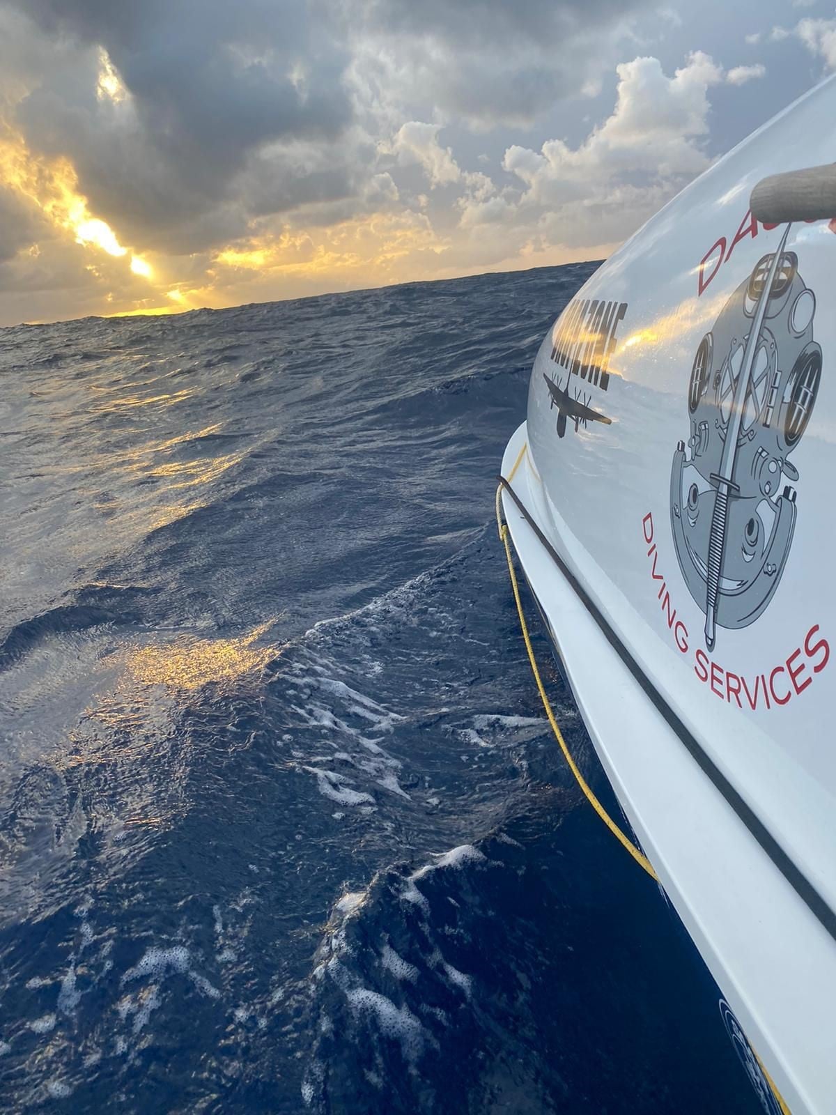 A boat in the middle of the ocean at sunset.
