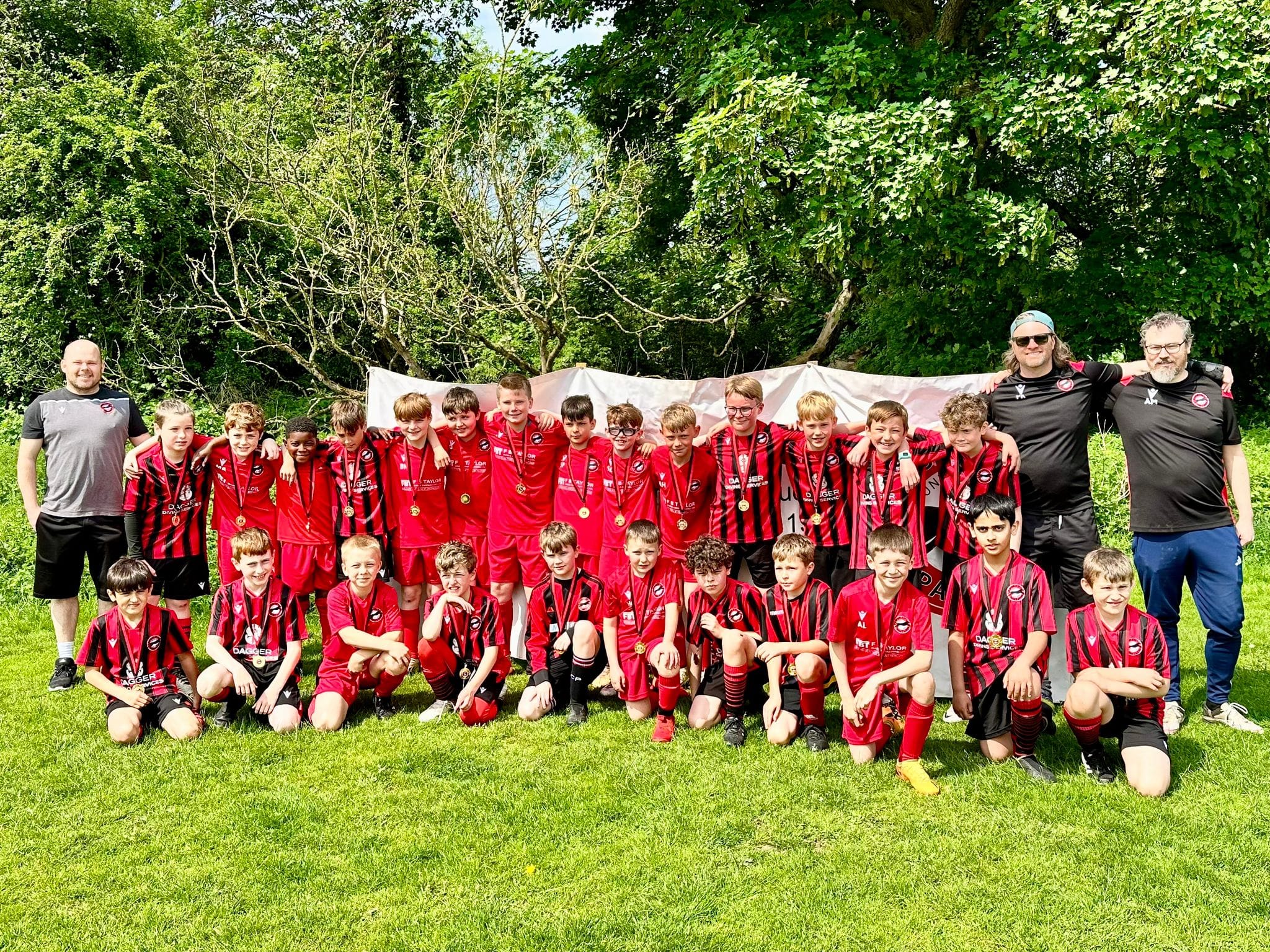 Ripon Panthers in their new kit A team of young football players posing for a team photo with their coach.